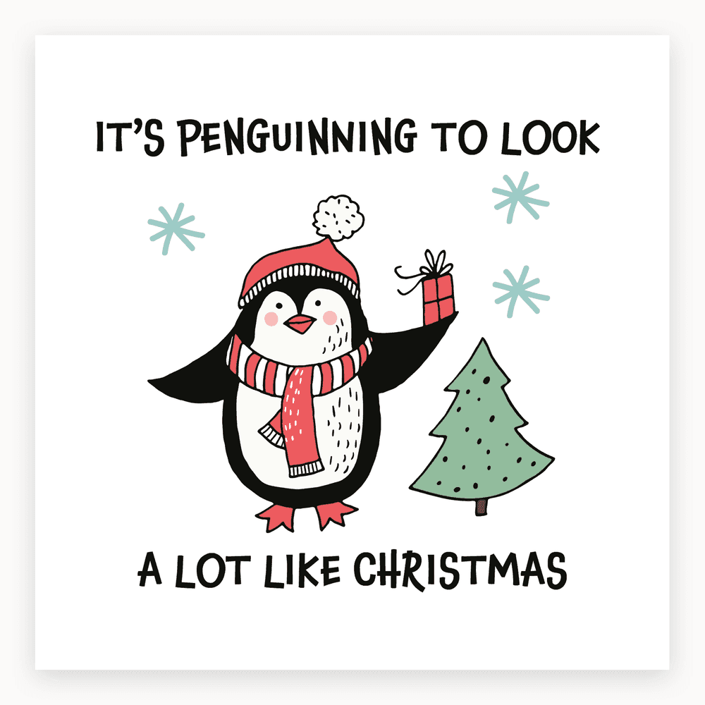 The card lying flat. Cheerful penguin in red hat and scarf holding a gift by a Christmas tree with 'IT'S PENGUINNING TO LOOK A LOT LIKE CHRISTMAS' text.